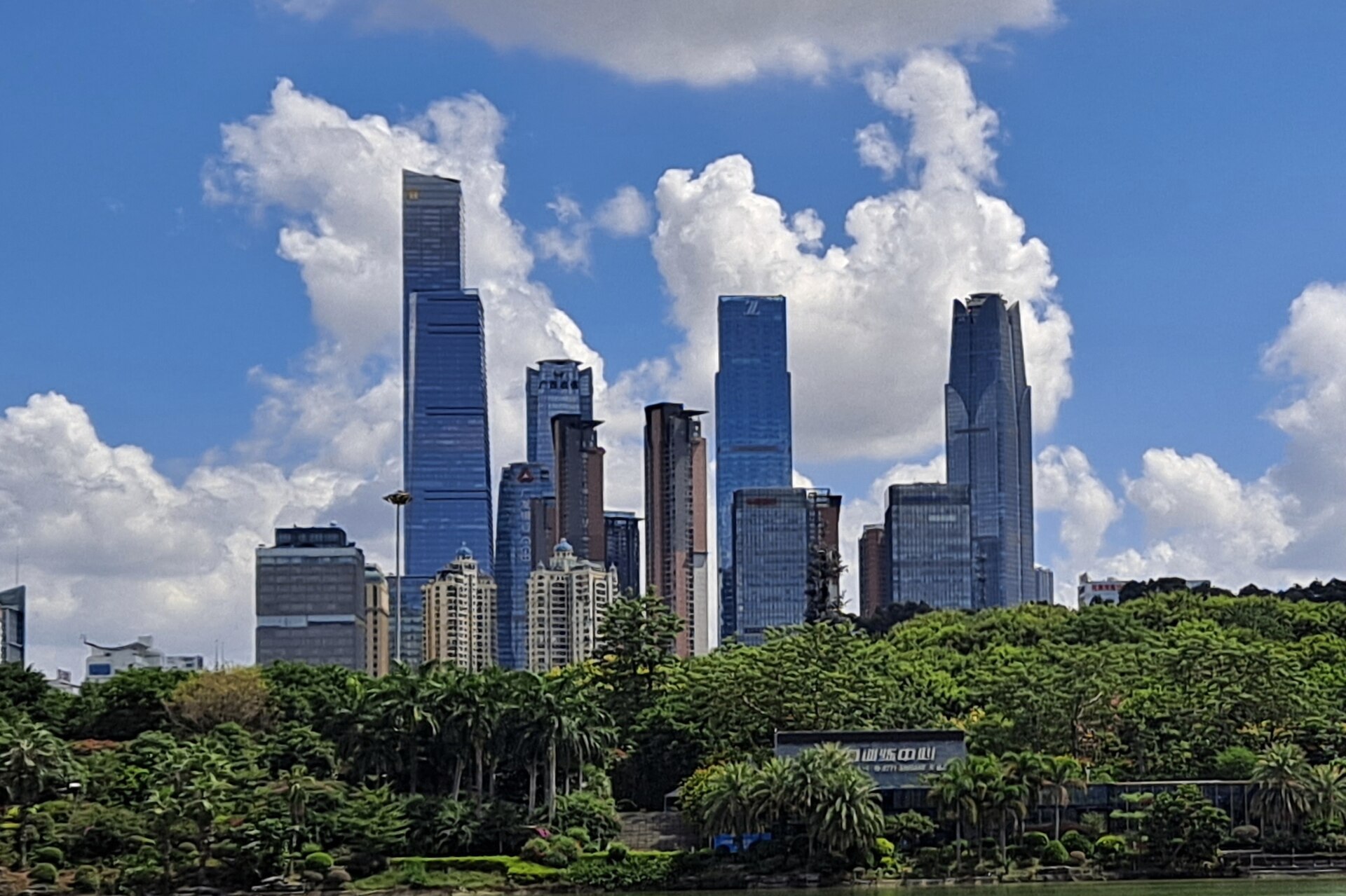 Nanning business district towers beneath a bright blue sky with lush green trees