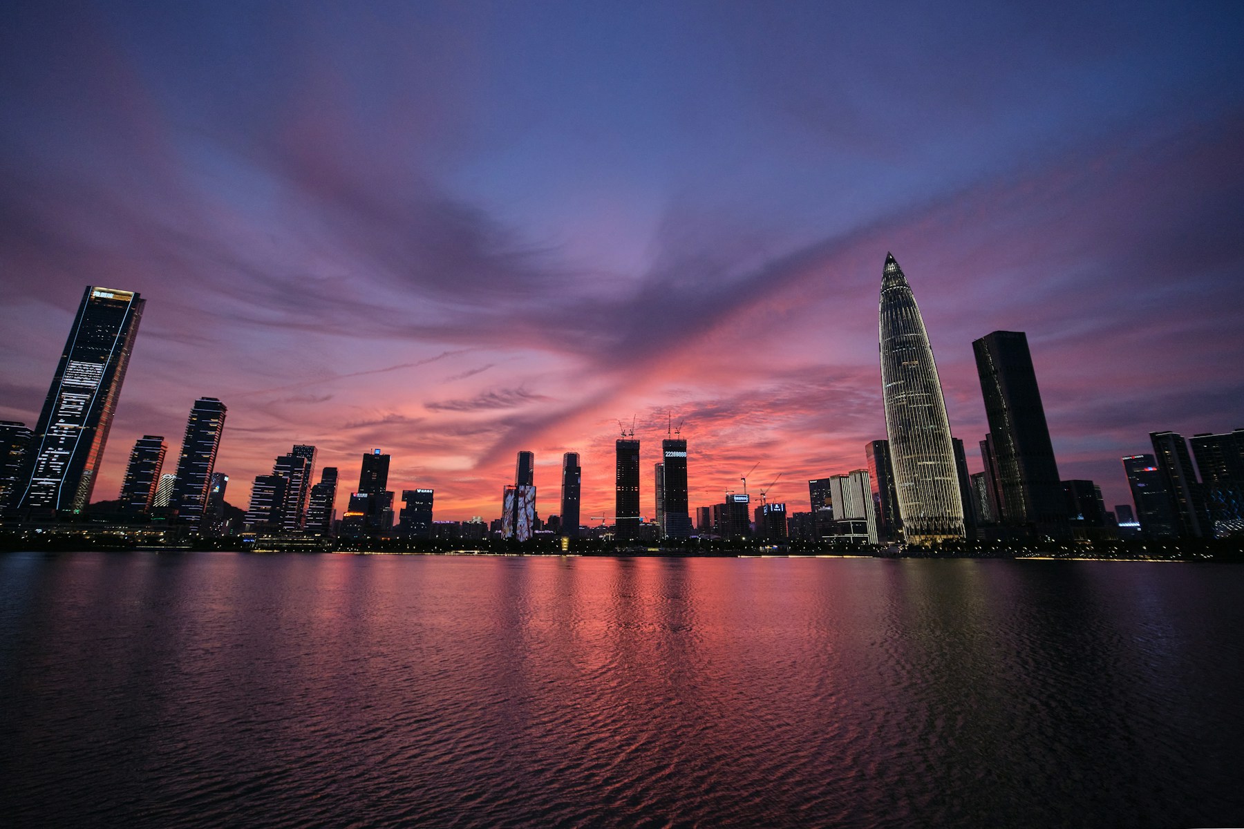 Shenzhen waterfront skyline beneath a pink and purple sunset